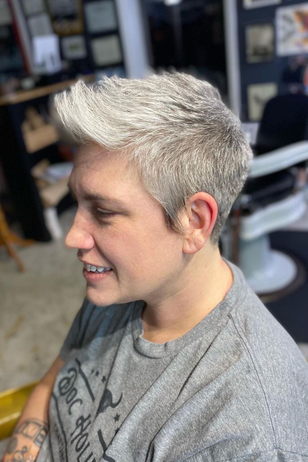 A woman with a long feathered gray pixie cut with sideburns.