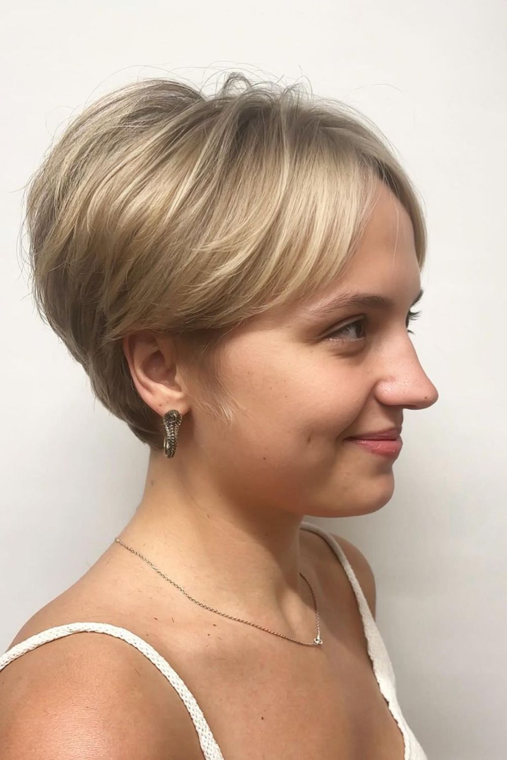 A woman with a blonde long pixie cut.