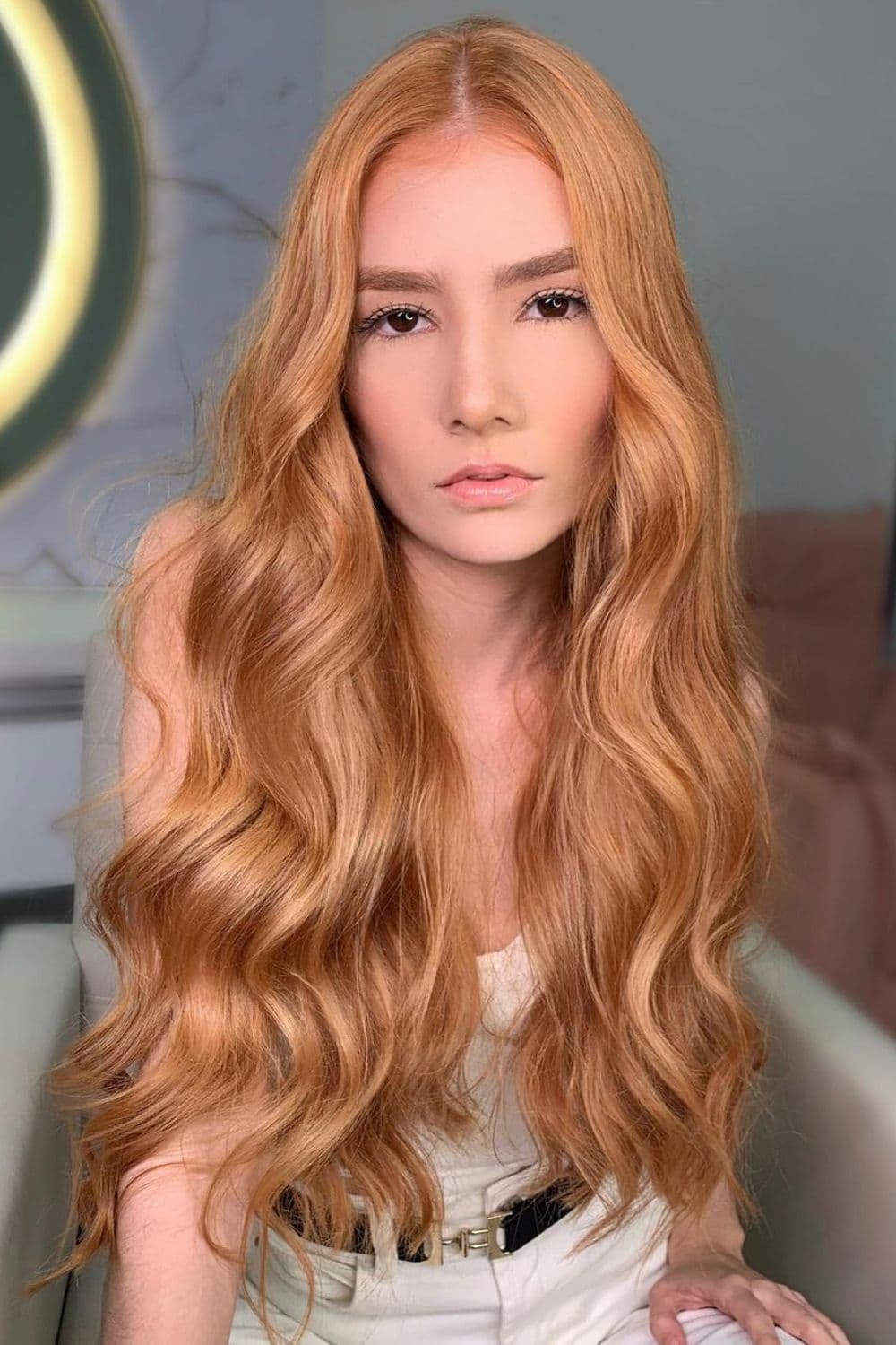 A woman with long wavy strawberry blonde hair.