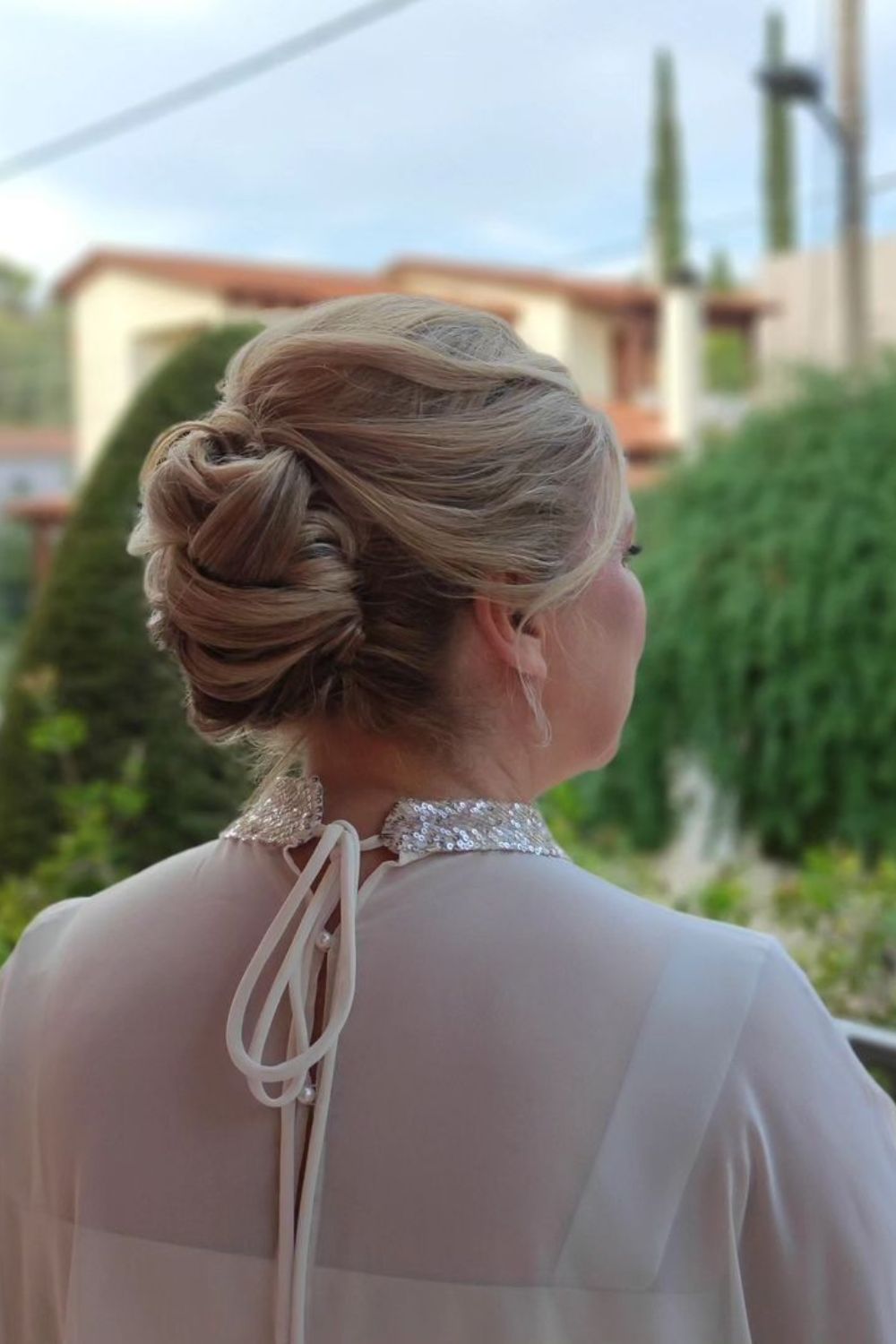 A woman with a blonde low chignon.