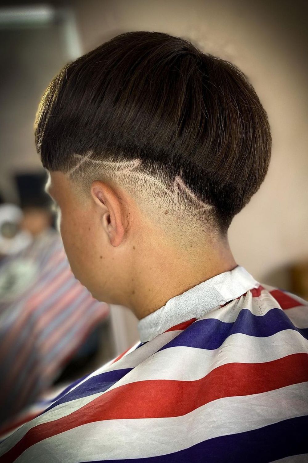 A man with a low fade cut with surgical lines.
