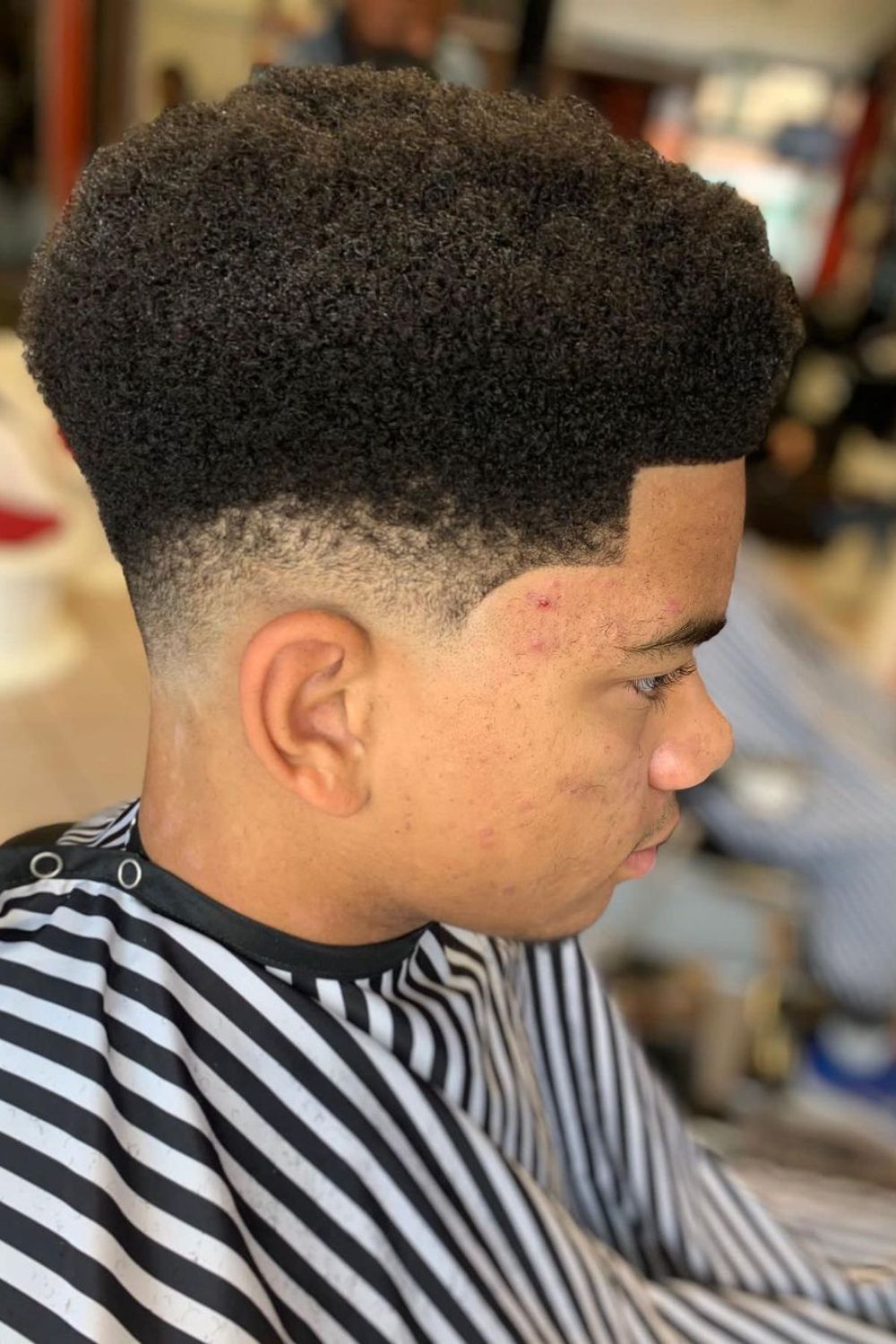 A man with a low-fade Afro haircut.