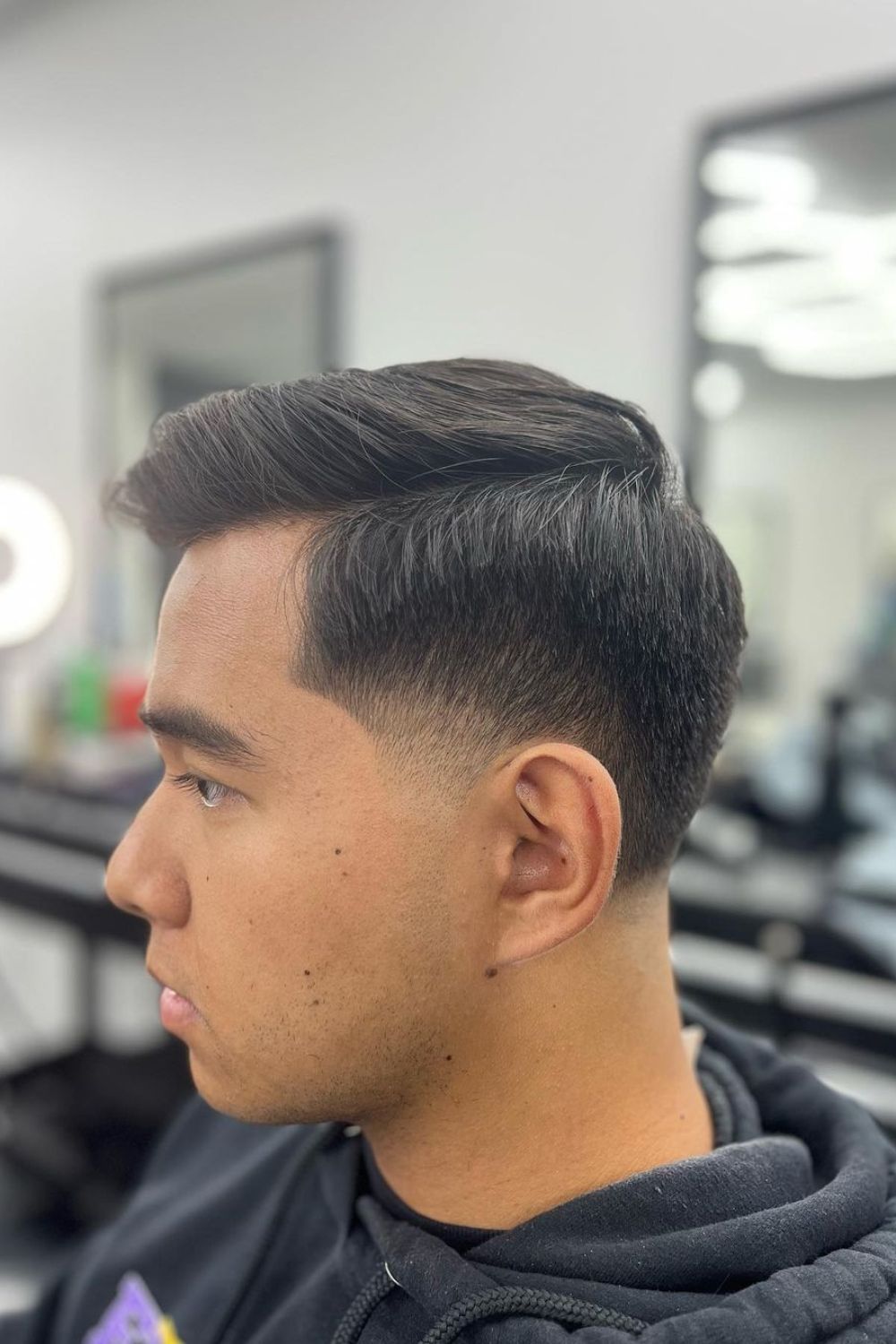 A man with low temple fade haircut.