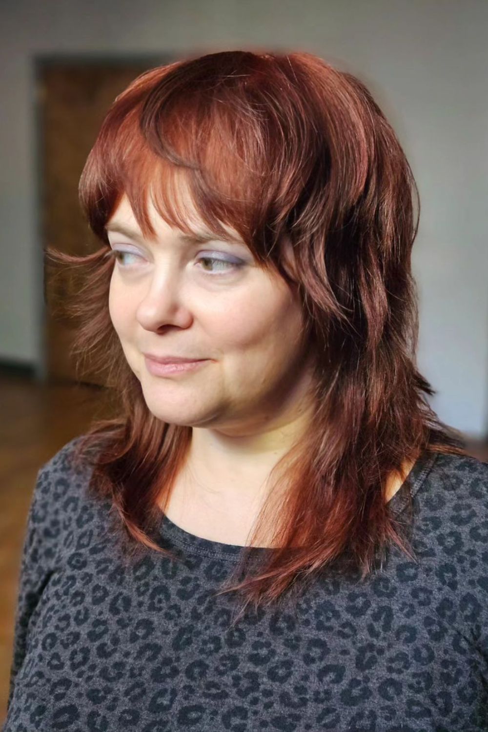 A woman with a medium-length copper shag with textured bangs.