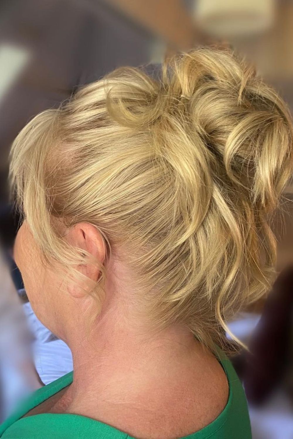 A woman with a blonde messy high bun.