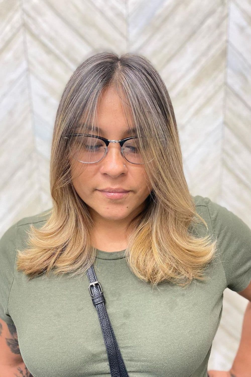 A woman with a middle-part medium-length ombre feather cut.