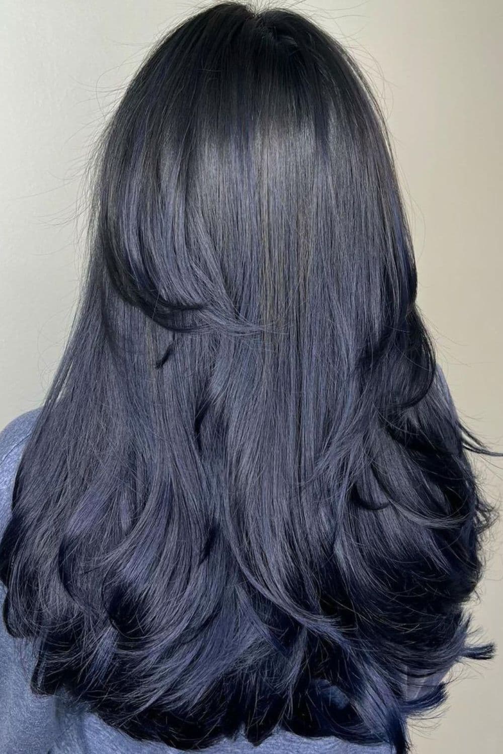 A woman with long layered midnight blue black hair.