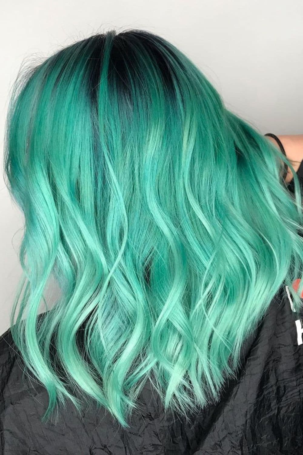 A woman with a mint green ombre hair.