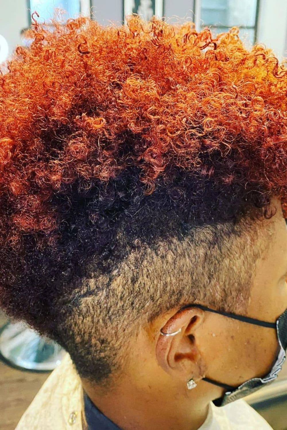 A woman with a short natural and fiery color undercut.