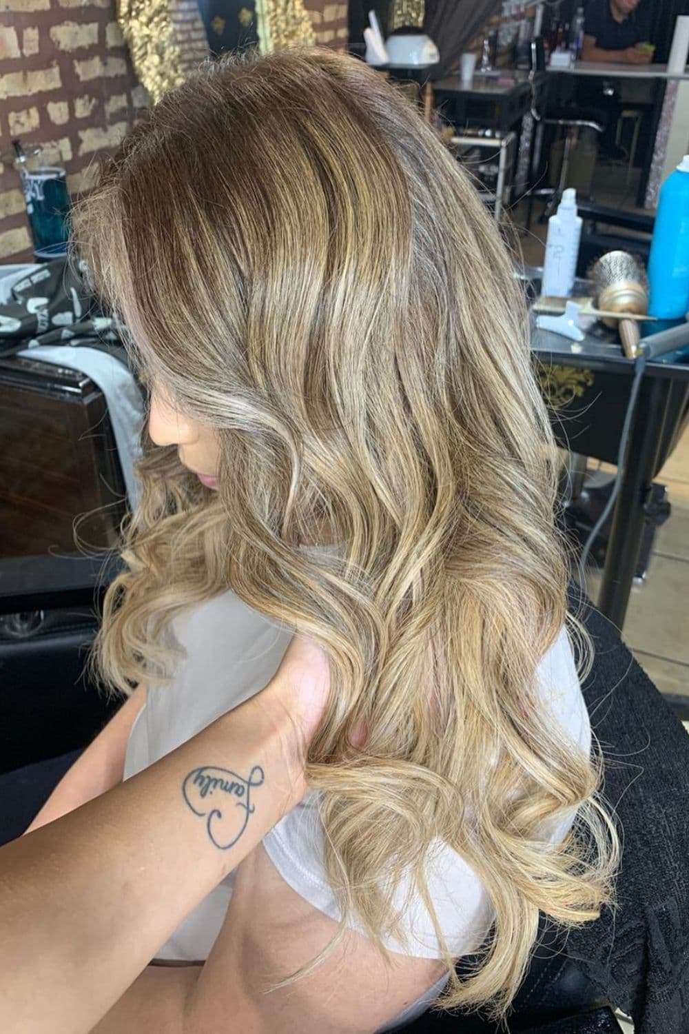 A woman with honey blonde ombre with money piece highlights.