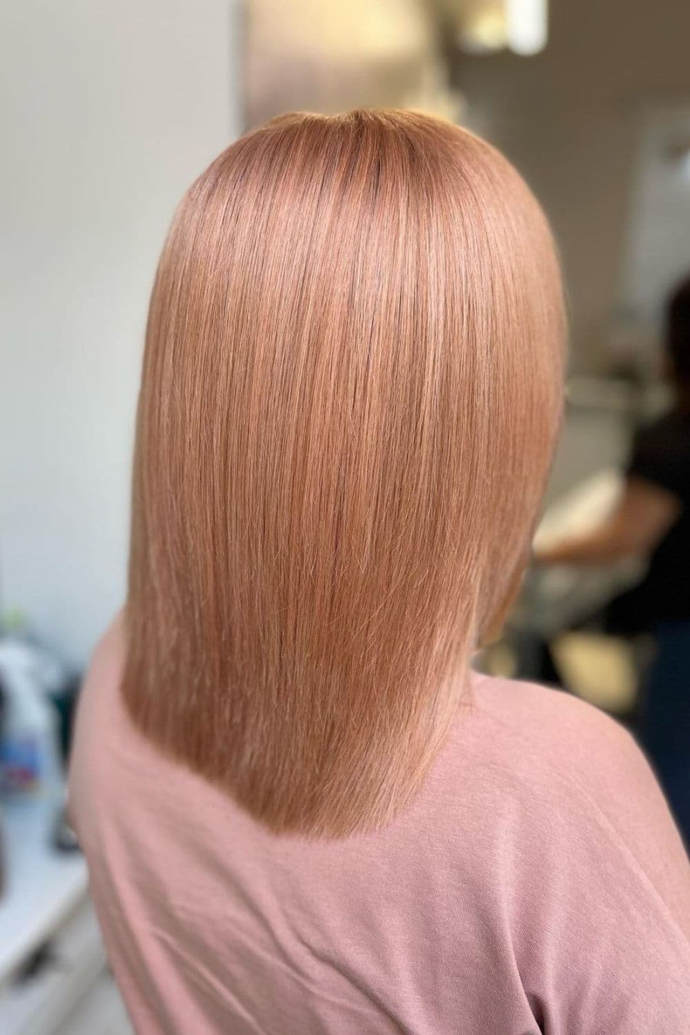 A woman with a straight, long bob peachy blonde.