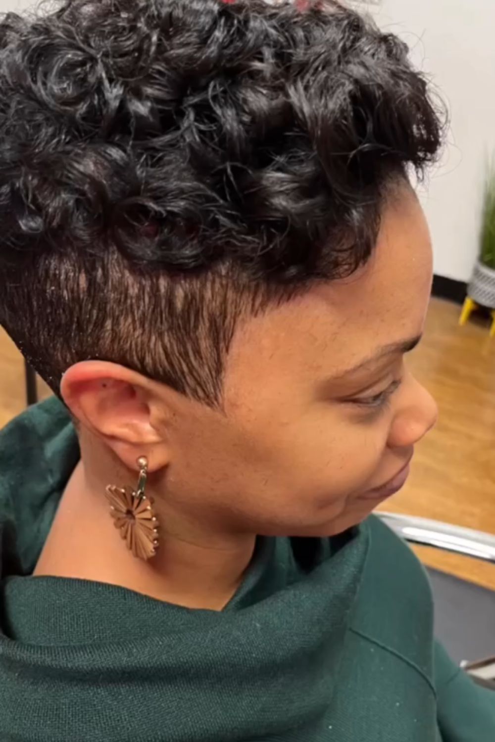 A woman with a curly pixie undercut.