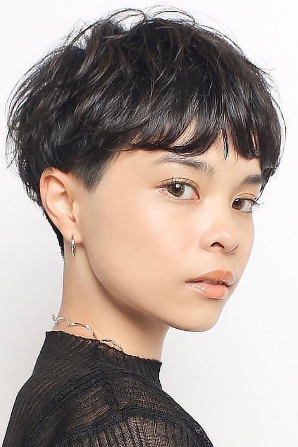 A woman with a black pixie with short bangs.