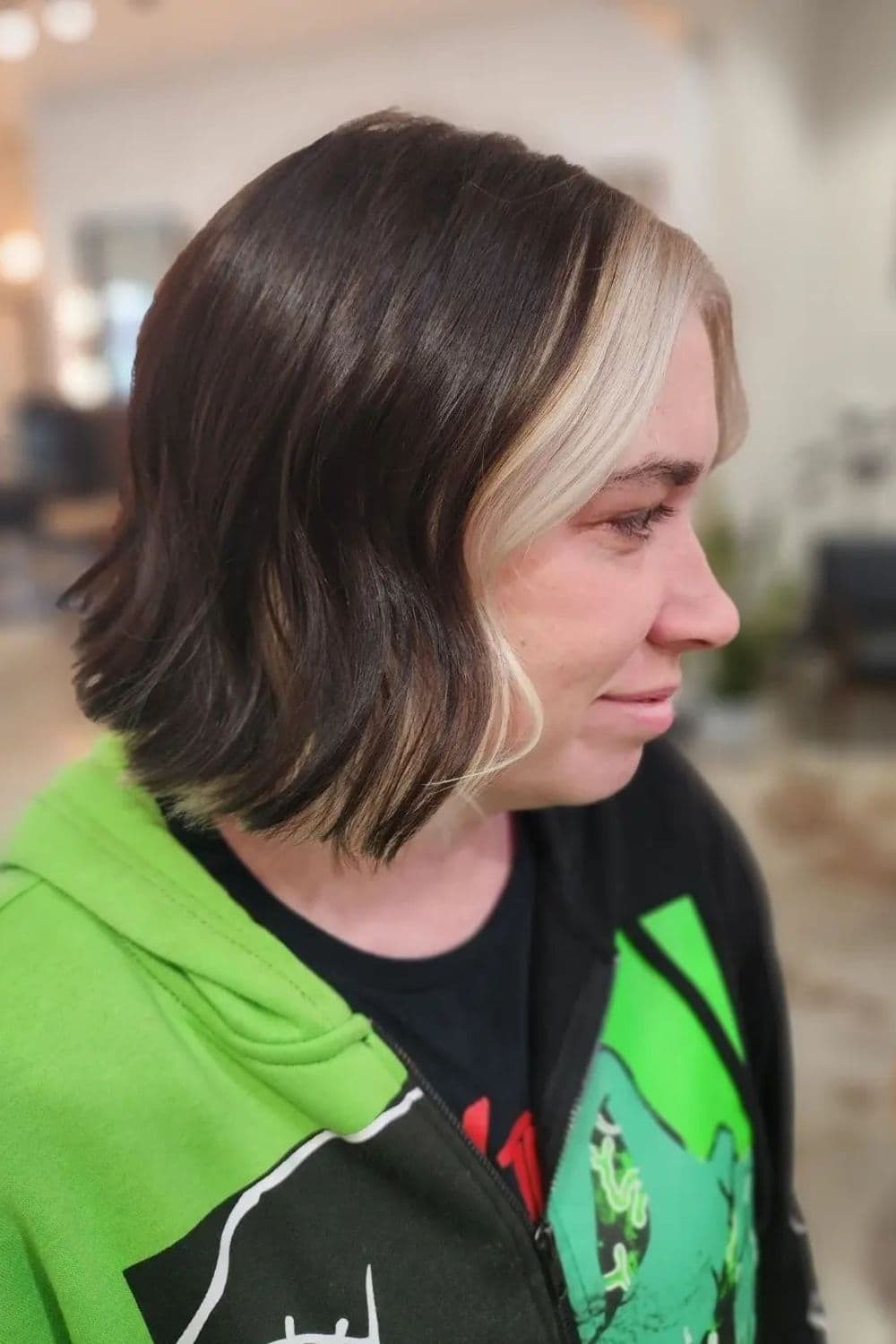 A woman with a brown bob cut with platinum blonde money pieces.