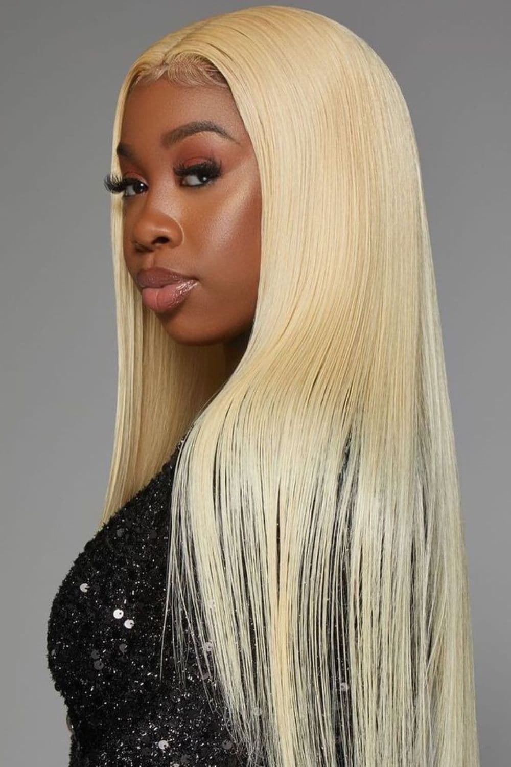 A woman with long straight platinum blonde quick weave.