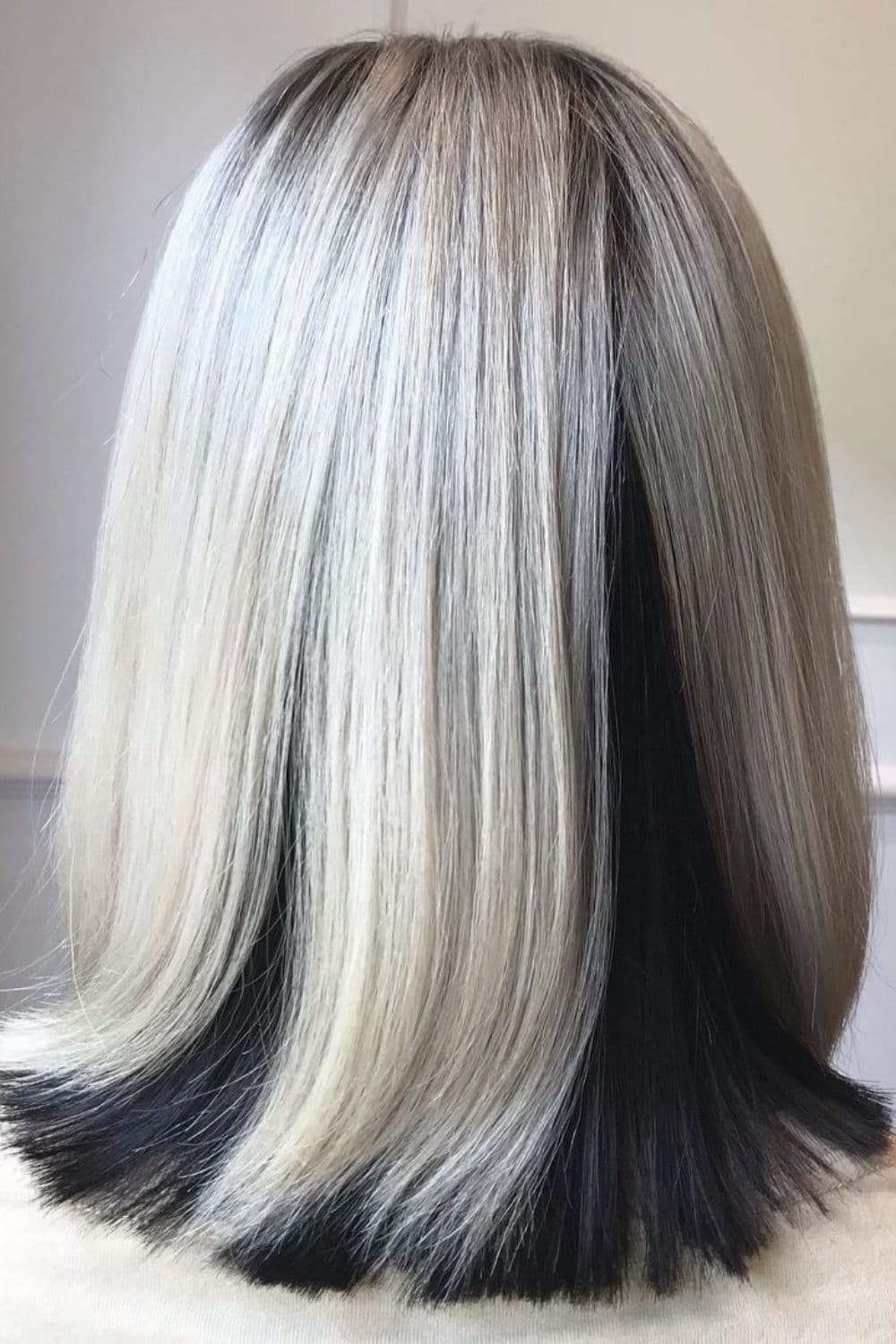 A woman with platinum blonde lob with black peekaboo.