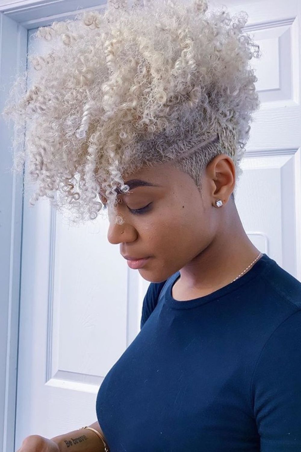 A woman with a platinum curly pixie.