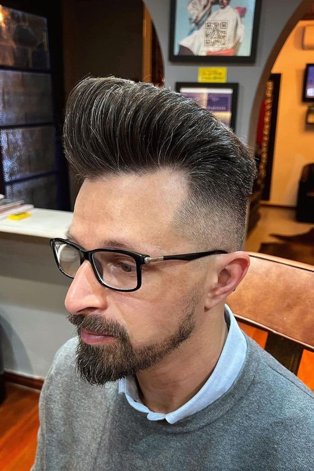 A man with a black and gray pompadour haircut.