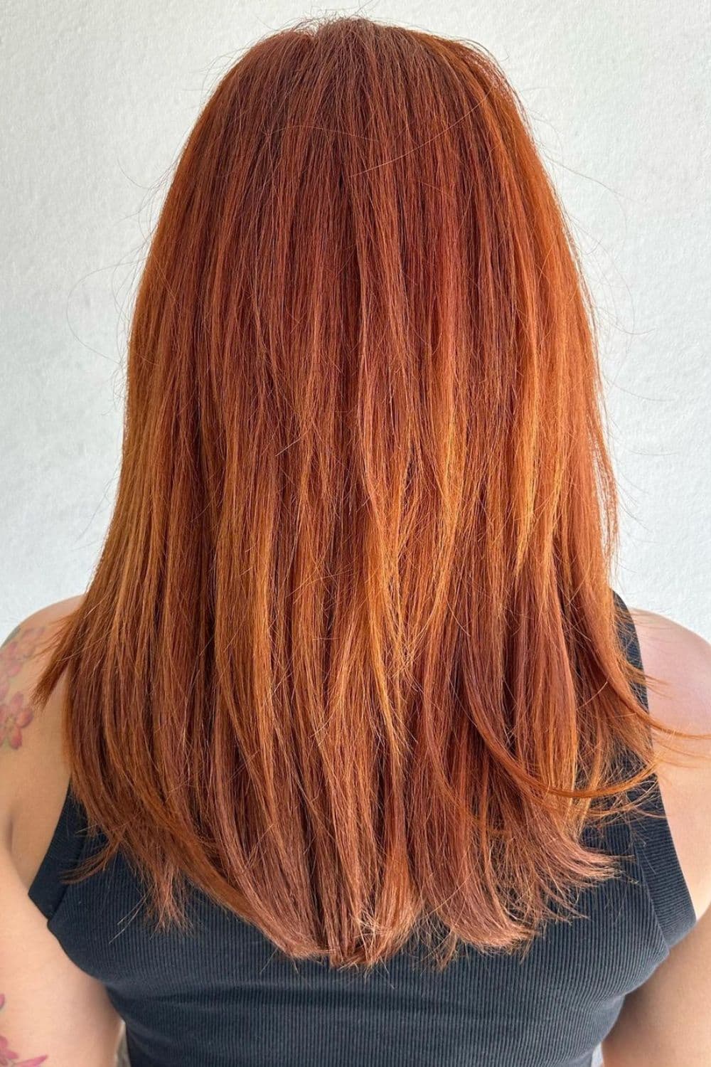 A woman with medium-length straight pumpkin spice red hair.