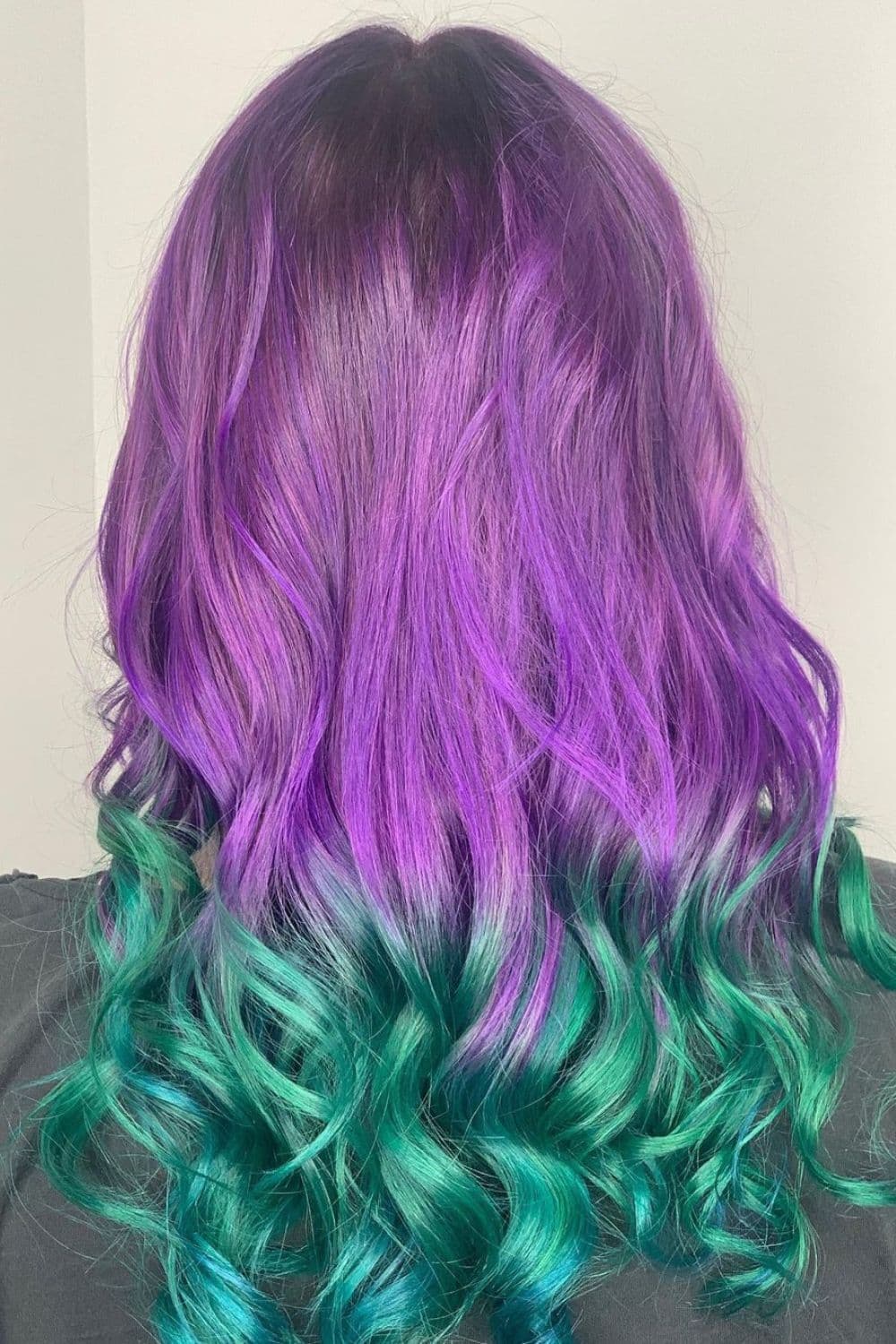 A woman with a purple to green ombre hair.