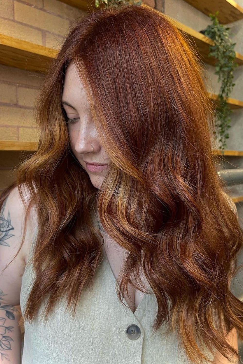 A woman with long copper red hair with strawberry blonde highlights.