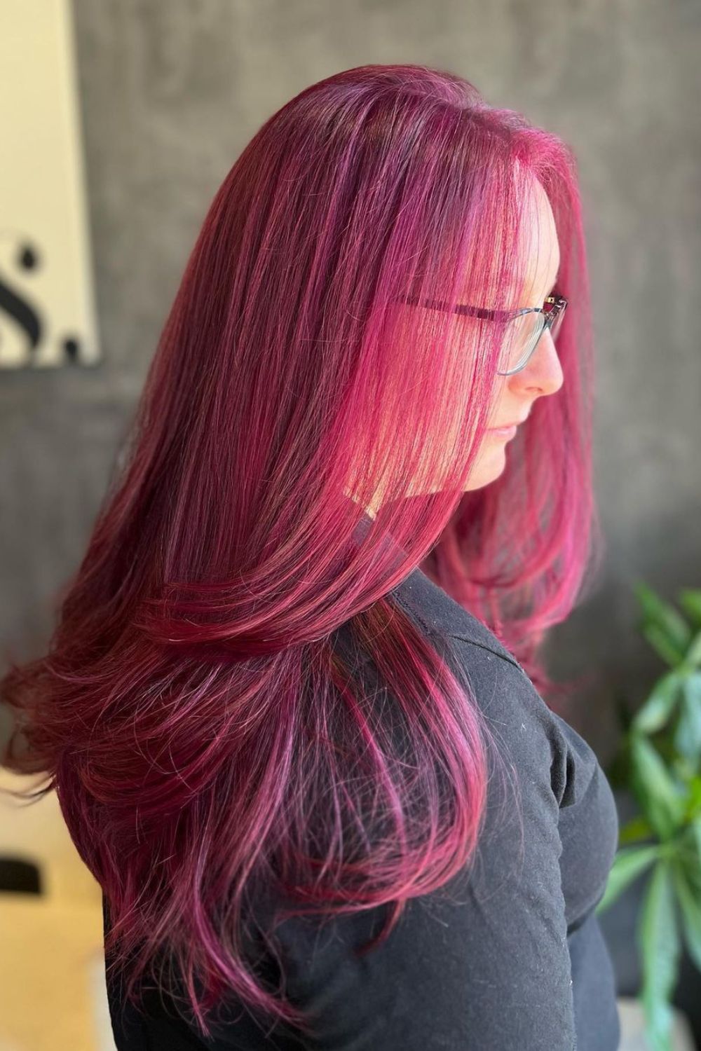 A woman with long straight violet red hair.