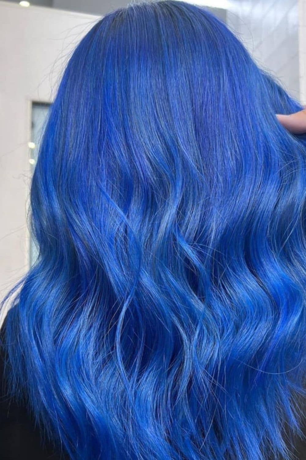 A woman with long royal blue hair with beach waves.