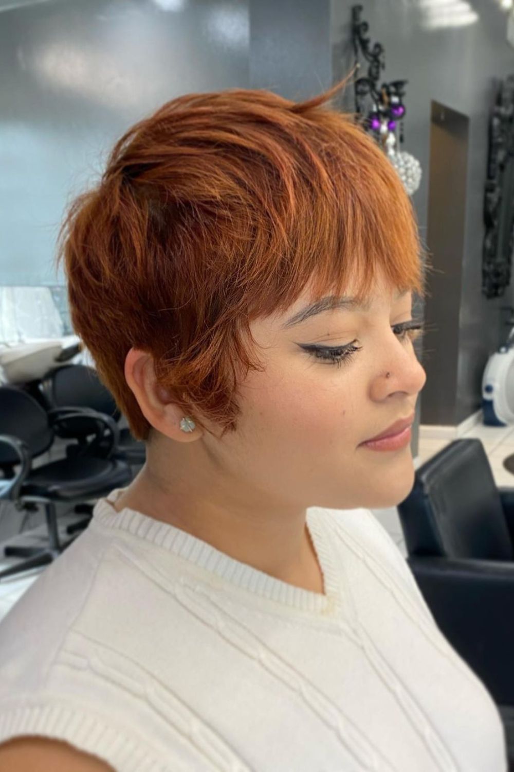 A woman with a copper shaggy pixie cut.