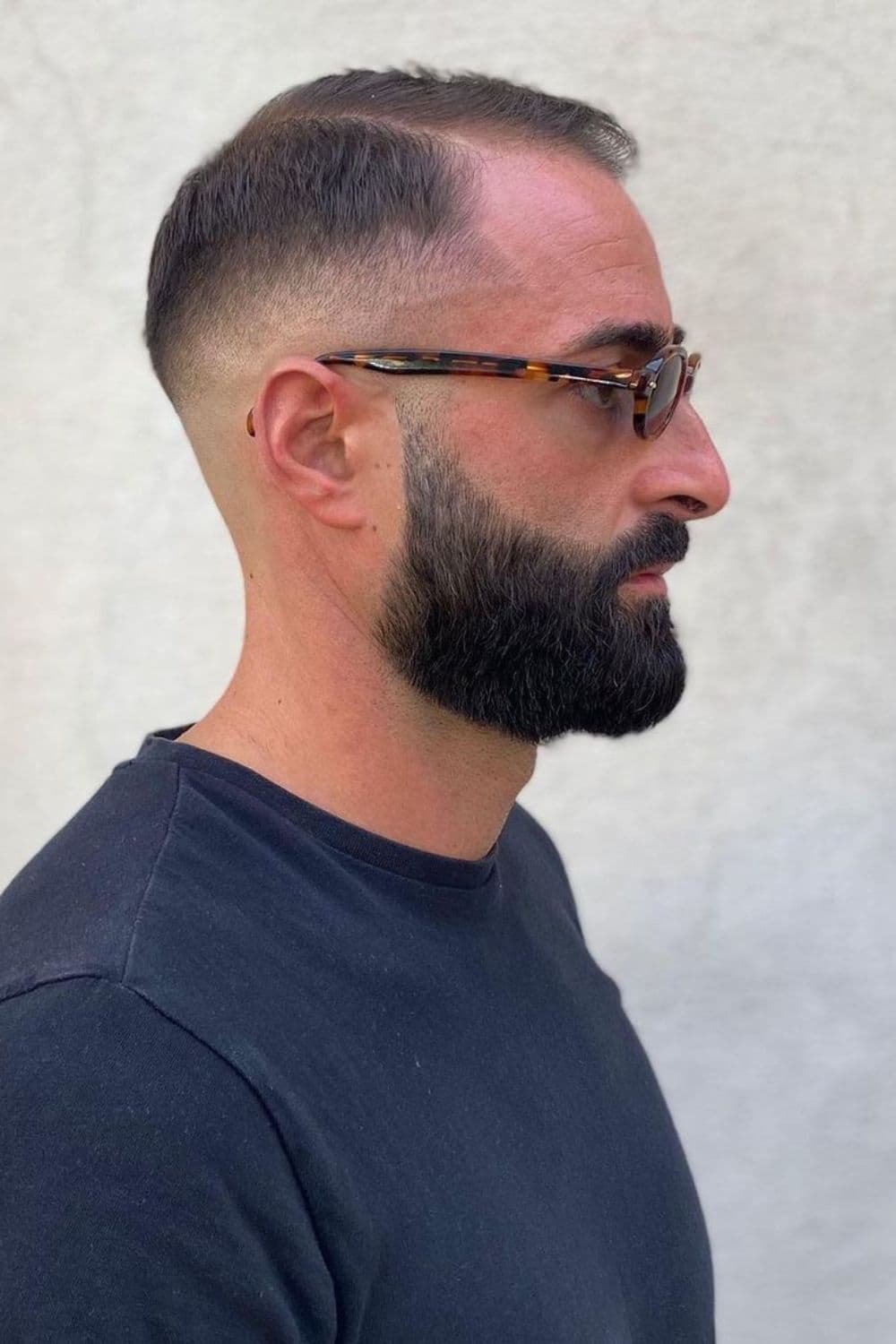Side view of a man wearing eyeglasses with a sharp razor fade haircut.
