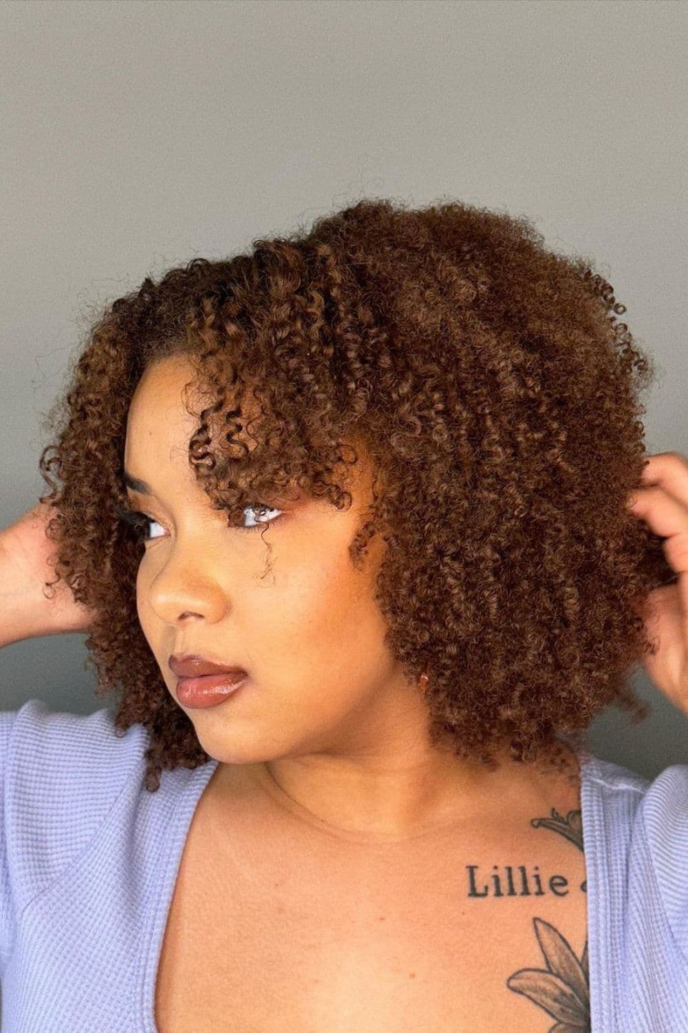 A woman with short brown natural 4C curls.