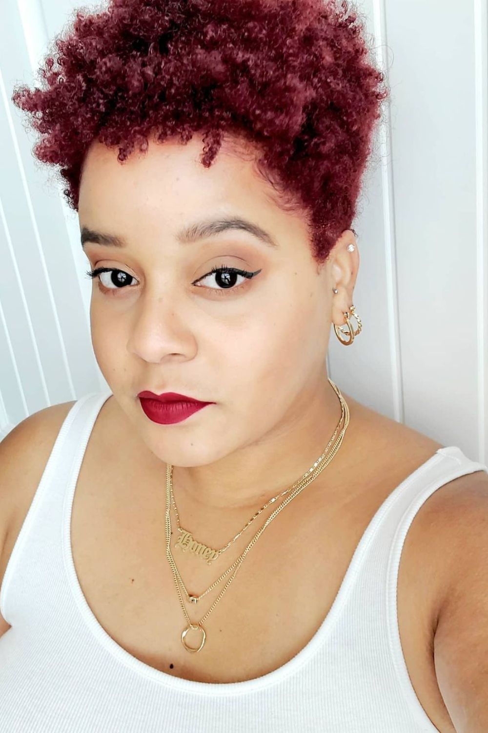 A woman with short red natural 4C hair.