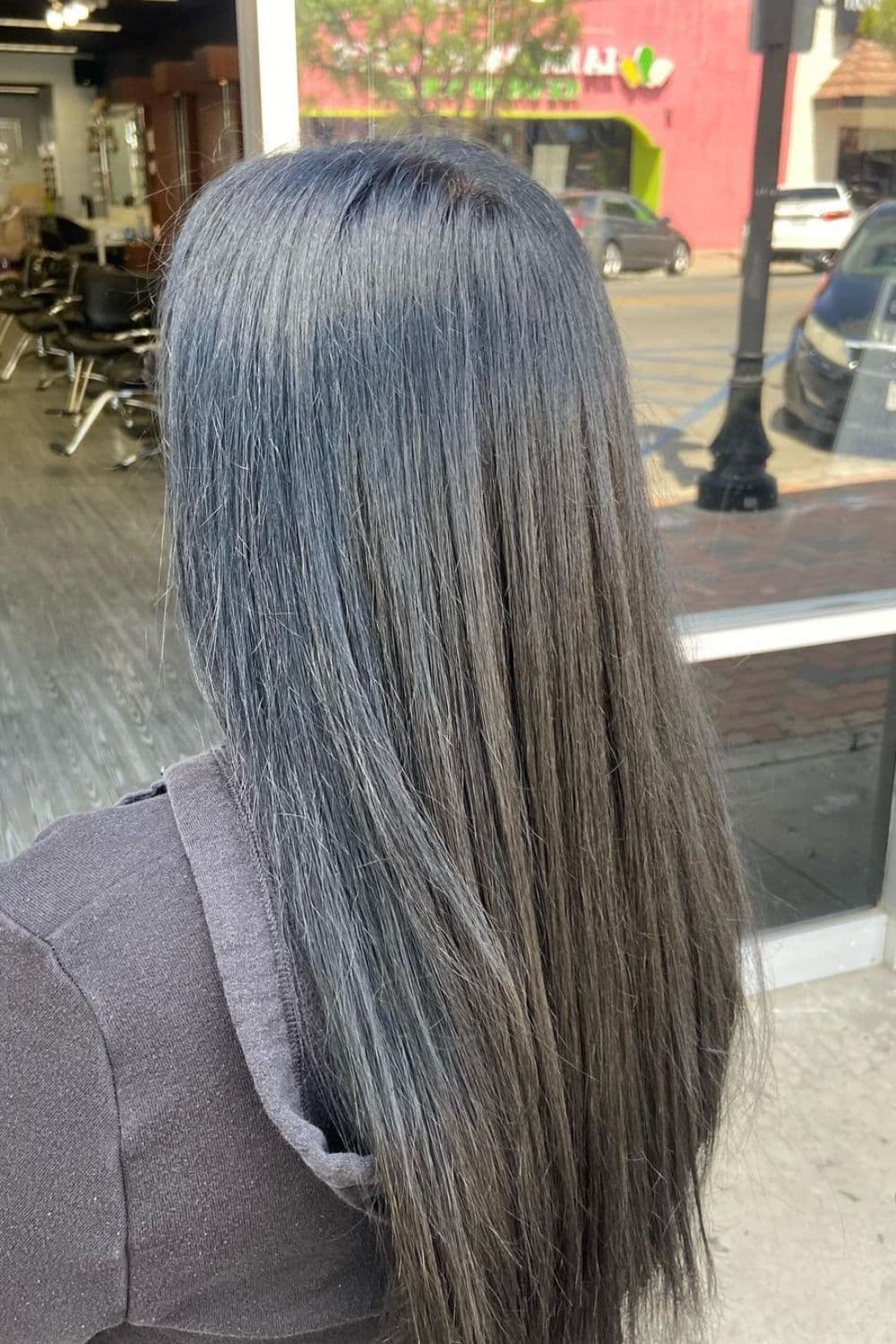 A woman with long straight silver blue black hair.