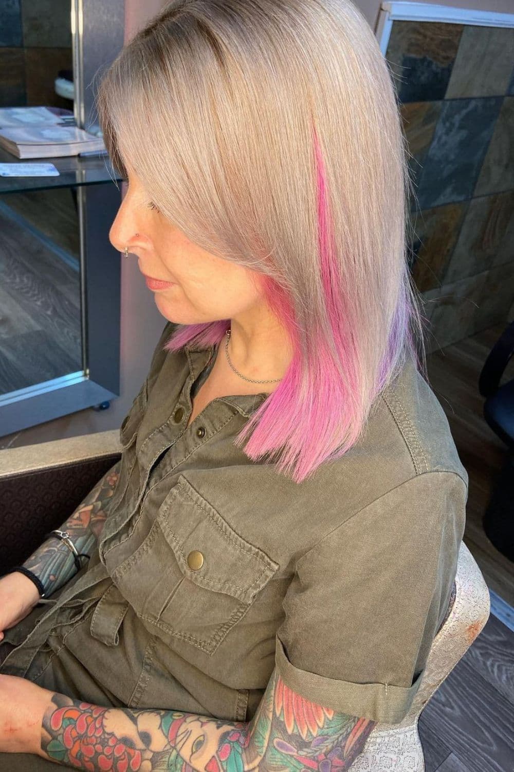 A woman with straight silver lob hair with pink peekaboo.