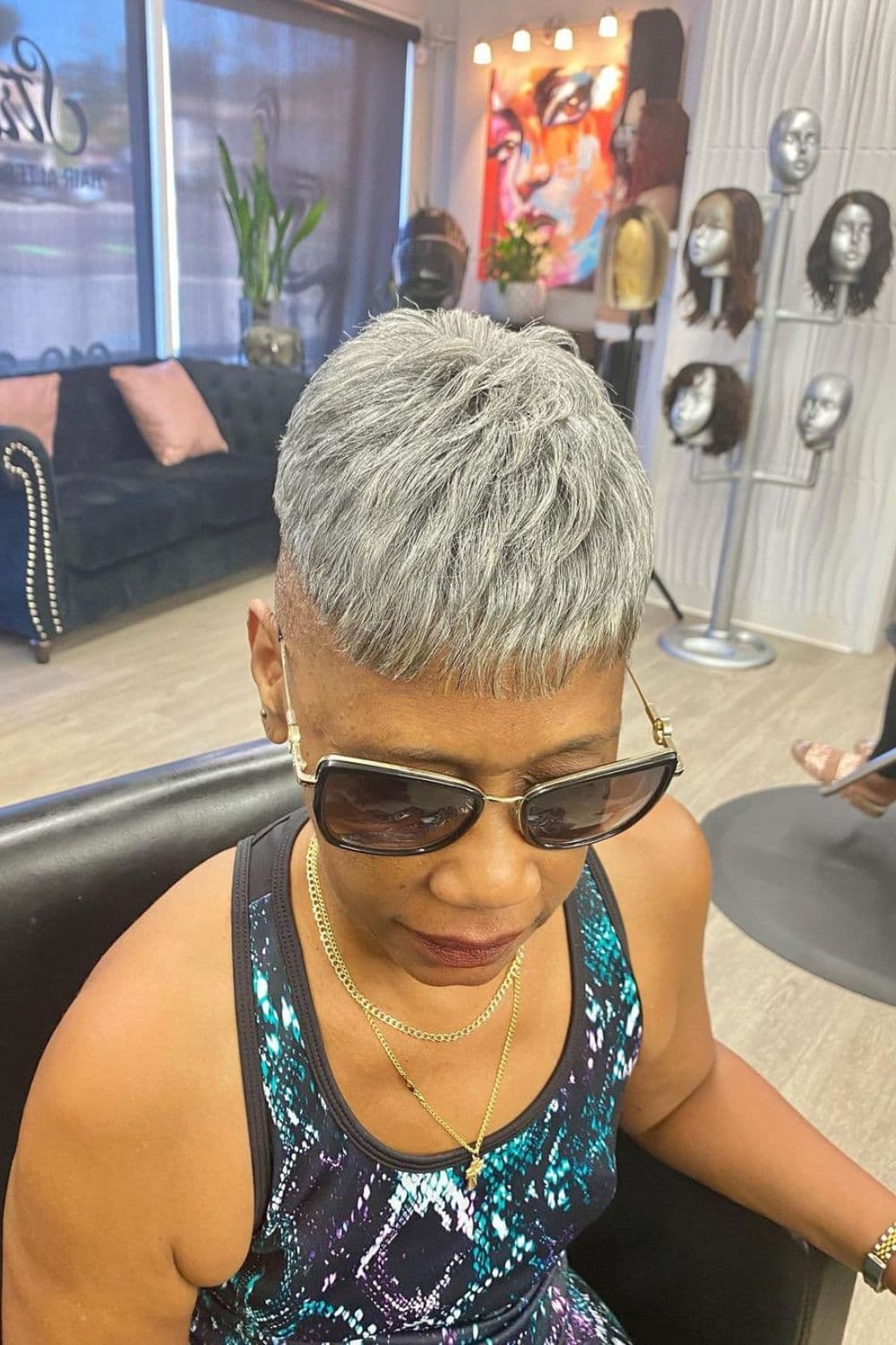 A woman with a short silver quick weave.
