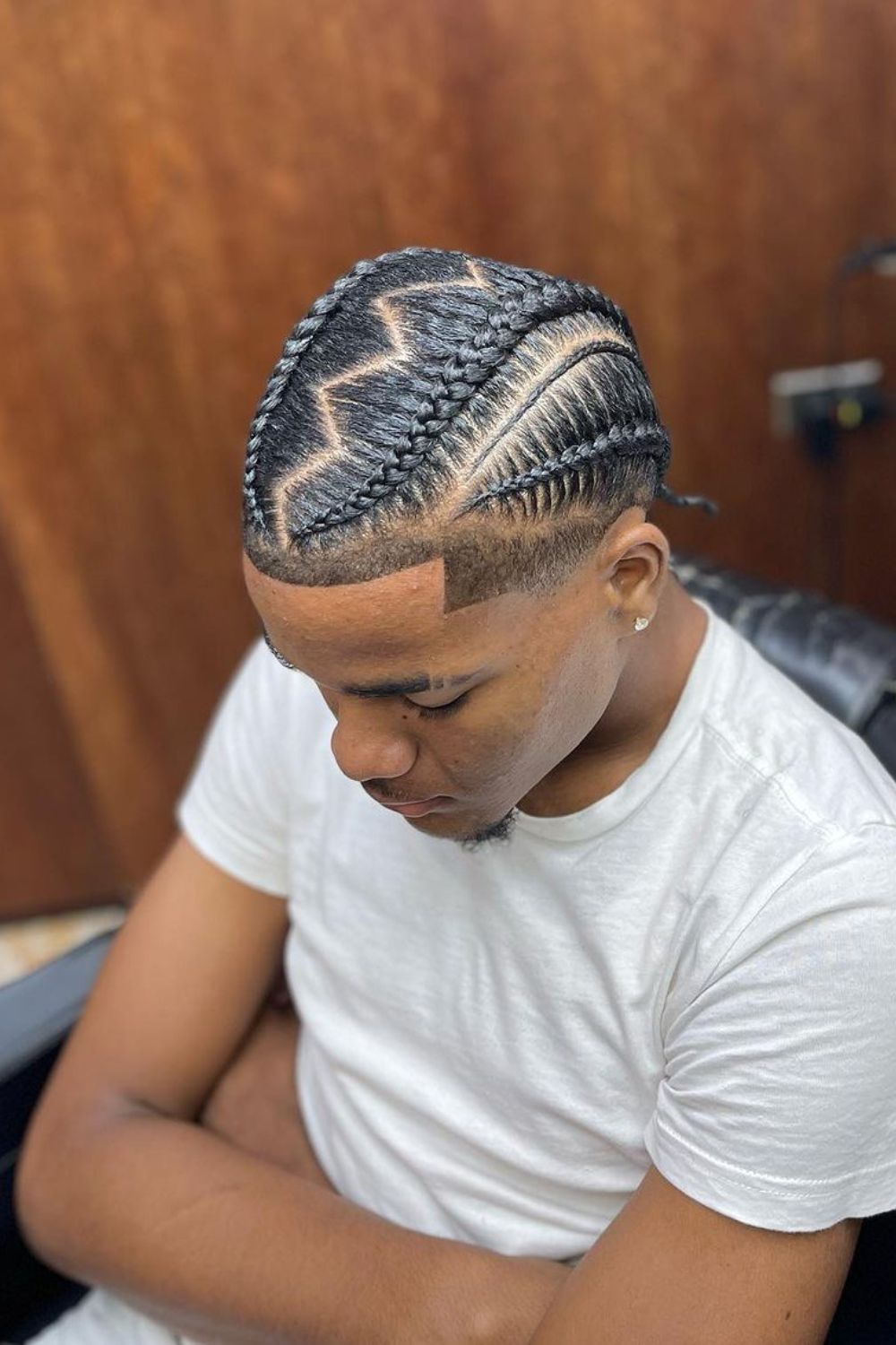 A man with a black slick back cornrows.