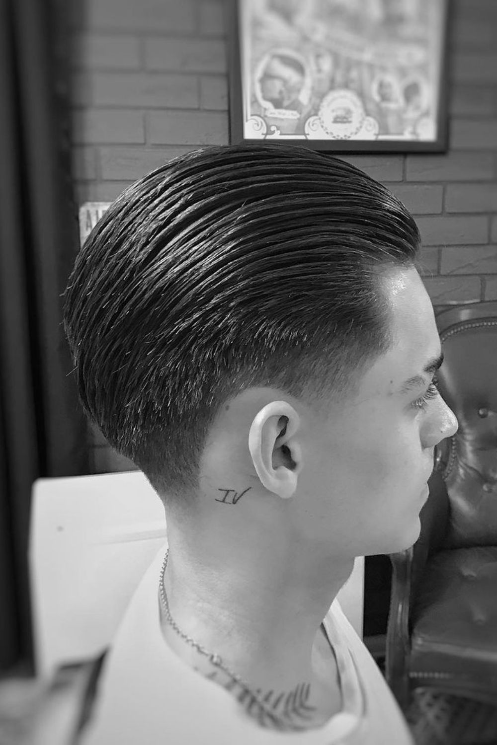 A man with a slicked back taper fade.