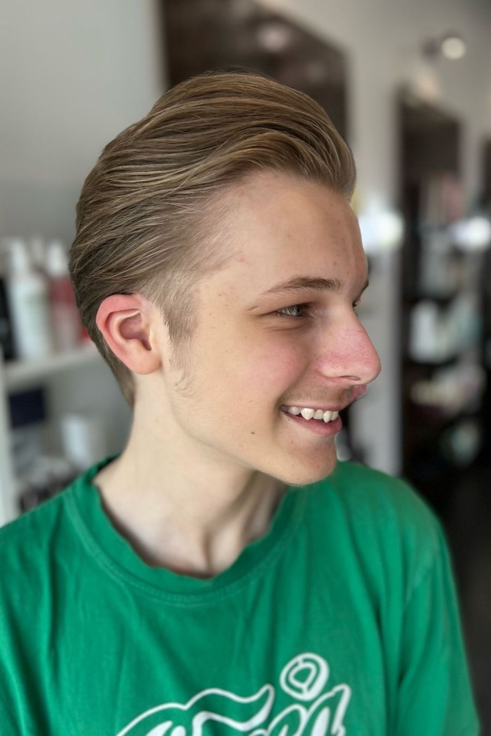 A man with a blonde slicked back hair.
