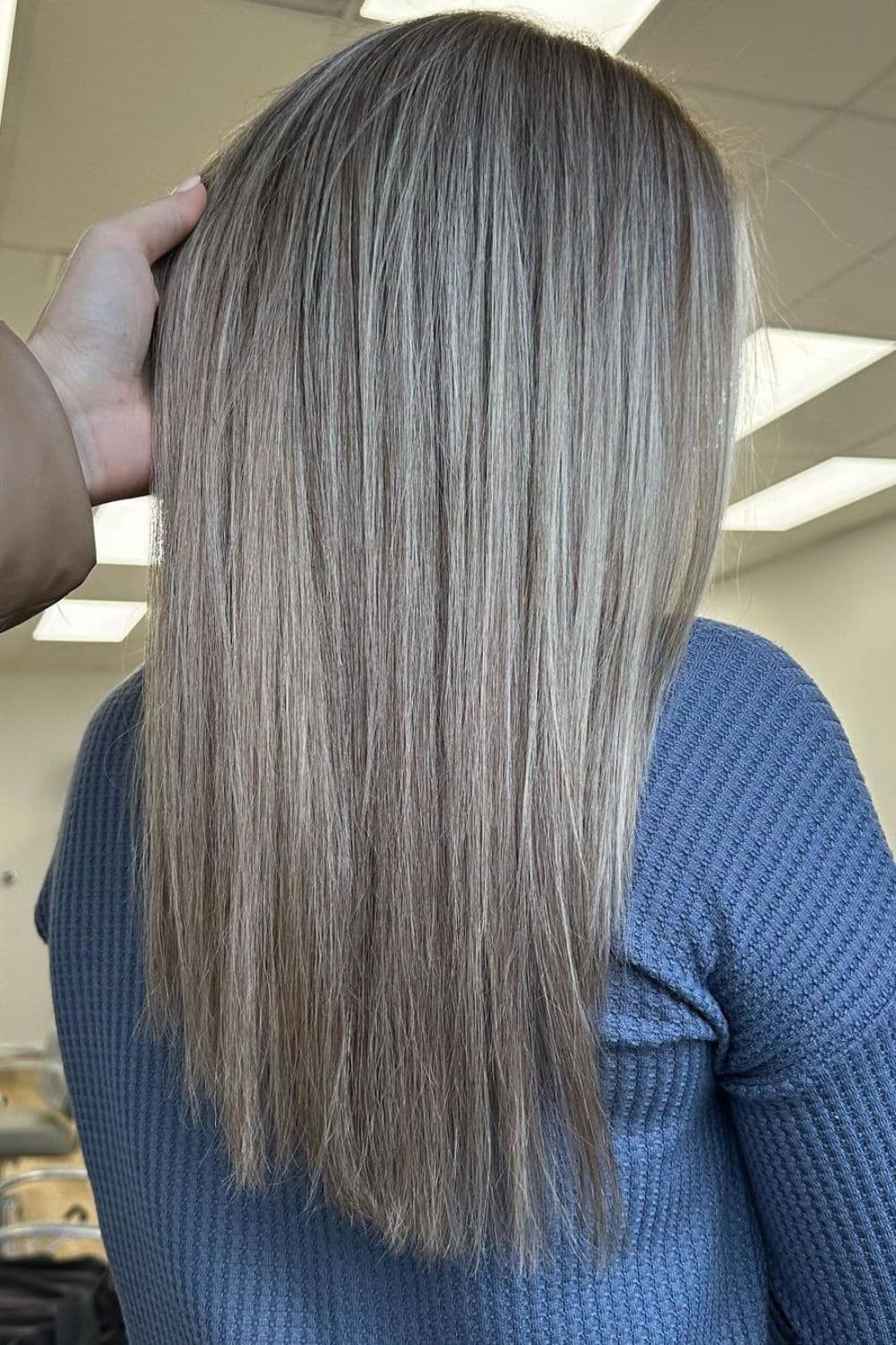 A woman with long straight smoky dirty blonde hair.