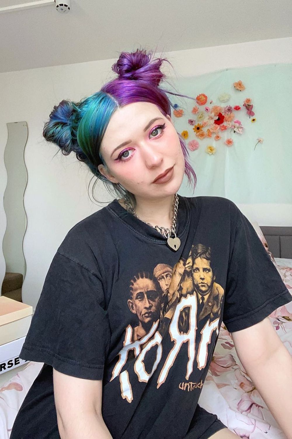 A woman with blue and violet split dye space buns.