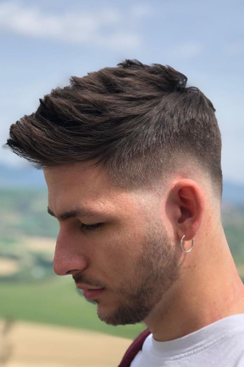 Side view of a man with a spiky high taper fade.