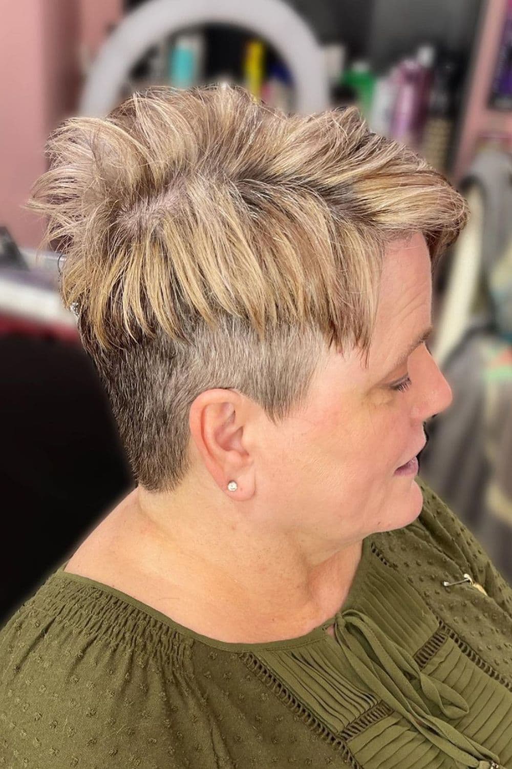 A woman with a blonde spiky pixie undercut.