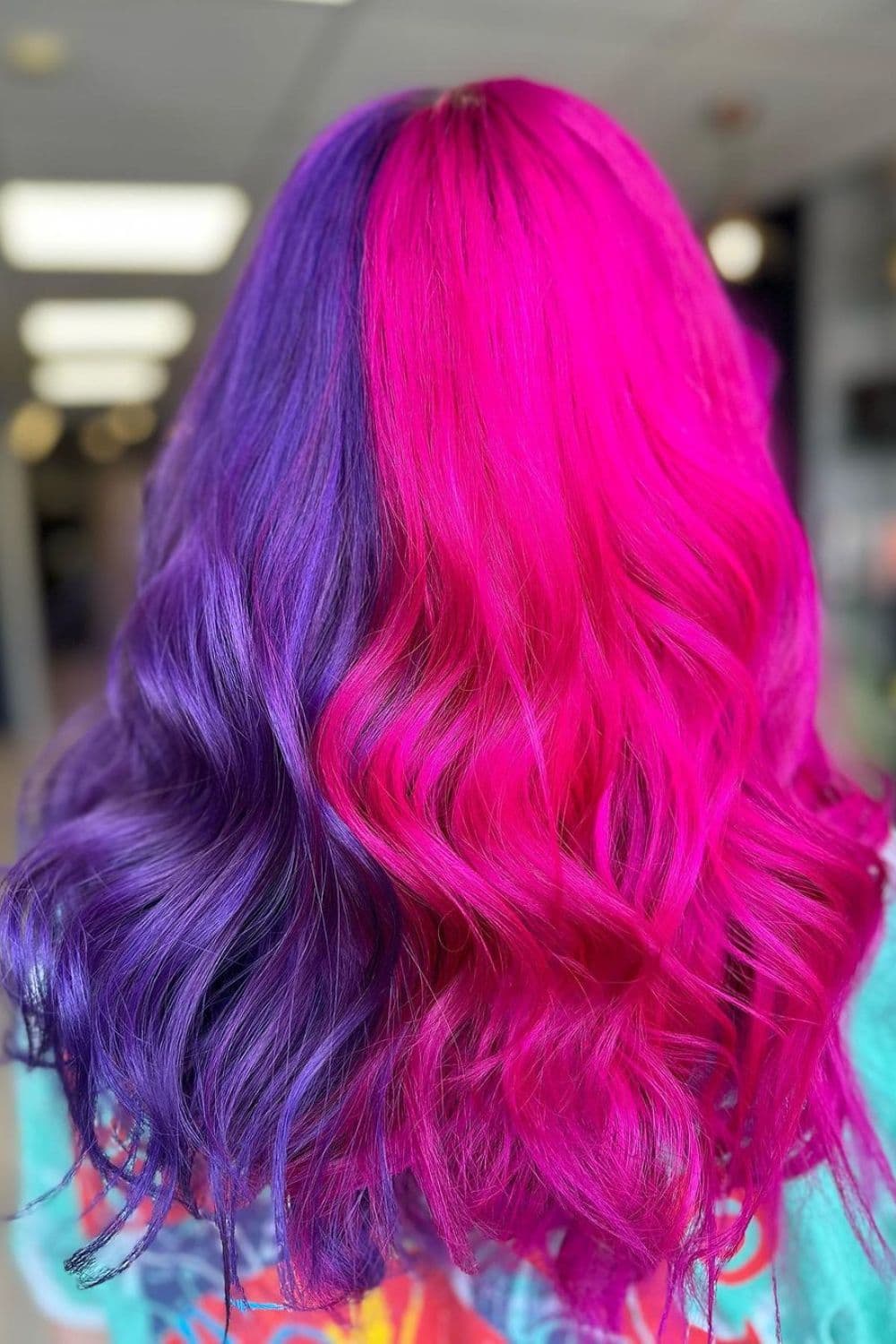 A woman with long purple and pink split-dye hair.