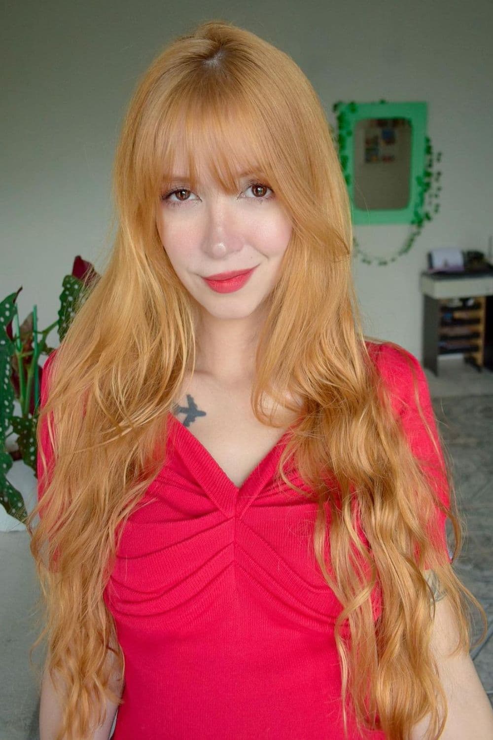 A woman with long strawberry blonde hair with wispy bangs.