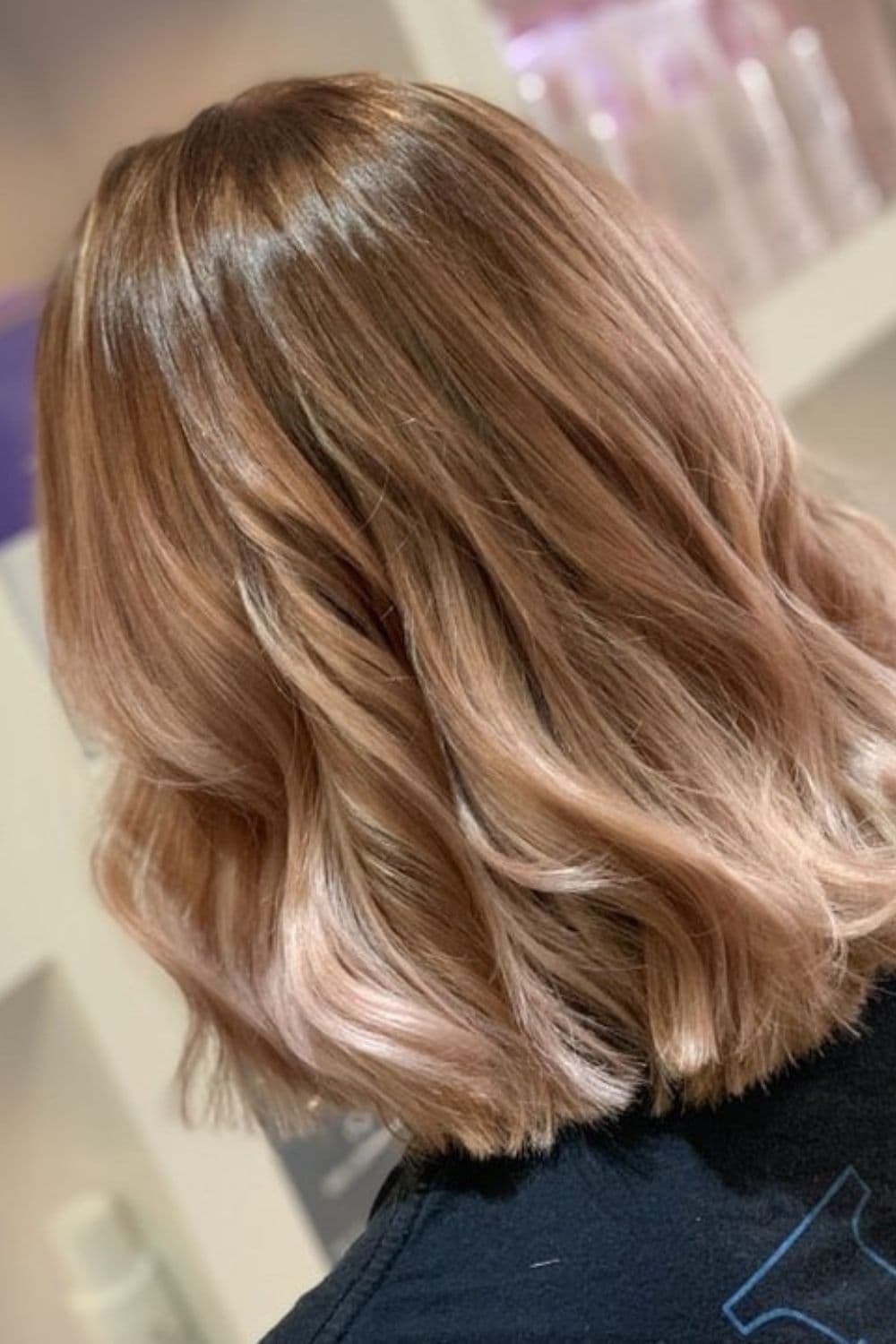 A woman with long bob strawberry blonde ombre.