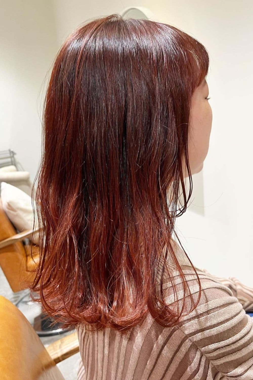 A woman with medium-length subtle red-orange hair.