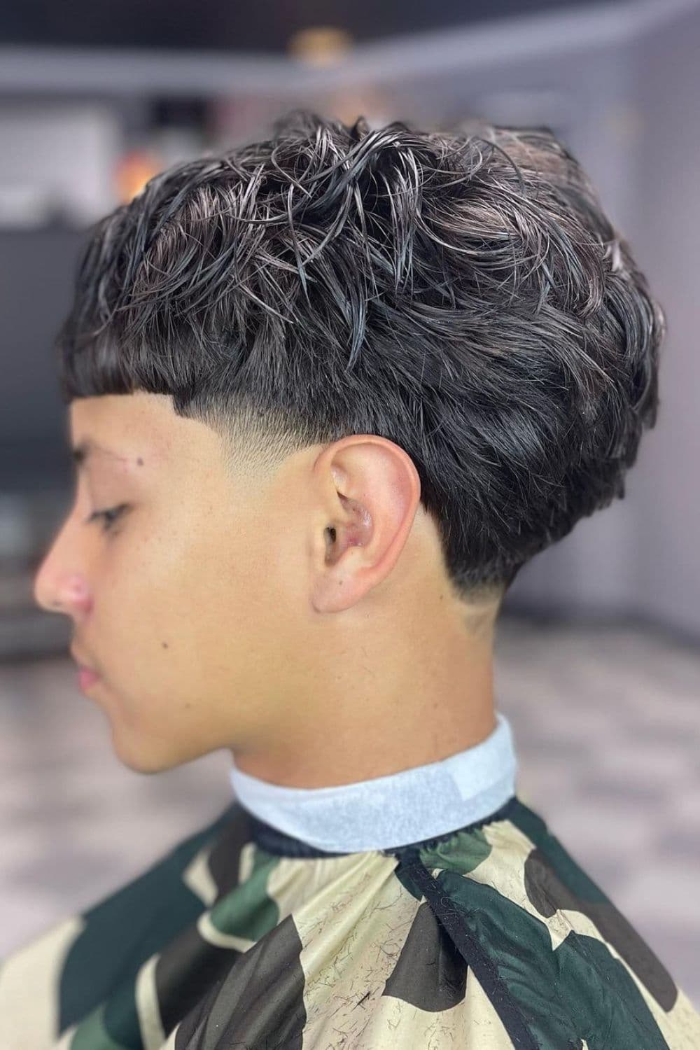 Side view of a man with taper fade Edgar cut.