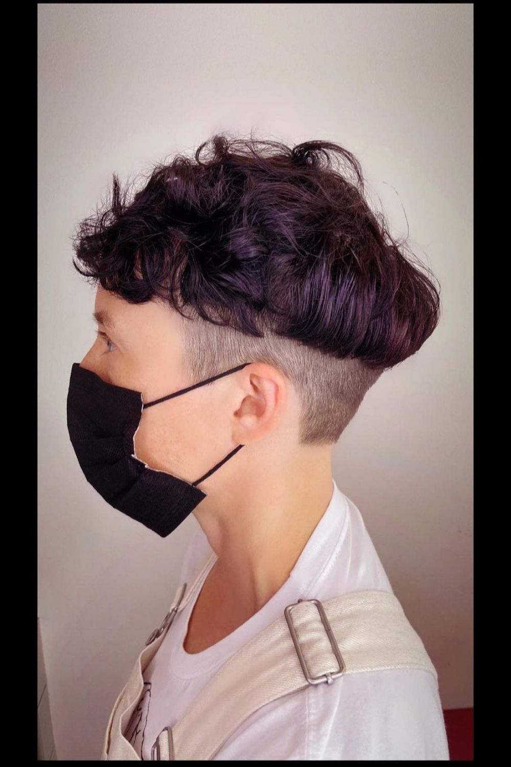 A woman wearing a black face mask with a textured bowl cut.