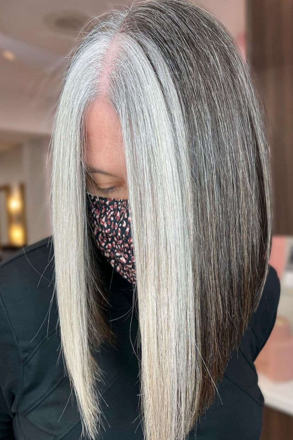 A woman with white money piece on gray hair.