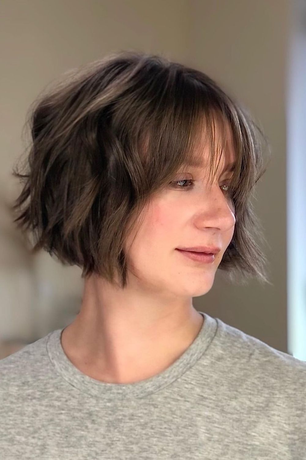 A woman with a wavy A-line bob with see-through bangs.