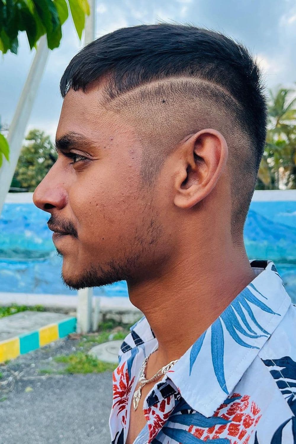 A man with a buzz cut with line up.